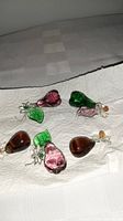 Five handblown Venetian glass ornaments in pear and leaf shapes on a white paper towel.