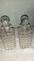 Both matching crystal decanters side by side, showing general shape and design.