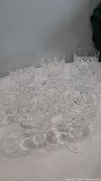 Eight Royal Doulton crystal stemware wine glasses with a diamond and star cut pattern arranged on a white surface.