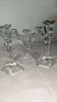 Photo showing all three crystal candlesticks; two single-stem and one three-stem candleholder, highlighting their shape and base design.