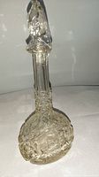 Full view of the decanter showing the tall, faceted stopper and detailed cut crystal designs.