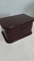 Closed view of dark brown wooden jewellery box with smooth finish.