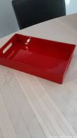 Full view of solid red lacquered wooden box on table.