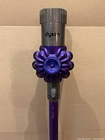 Close-up of Dyson cyclonic main vacuum body in purple and gray.