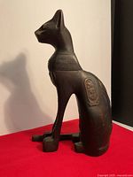 Side view of the cat statue showing hieroglyphic engravings on the side and the overall profile.