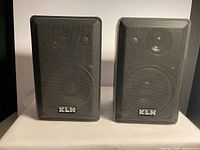 Front view of the pair of KLH Satellite 970A speakers showing black textured housing and mesh grills with KLH logo.