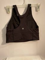 Front and back photos showing the black Lululemon workout top with racerback design and logo on back band.