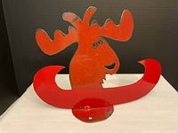 Full view of metal art piece showing a stylized moose head with antlers inside a red canoe on a white background.