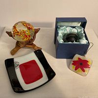 Photo of all items including Murano dish, two paperweights, pendant, and driftwood stand on white surface.