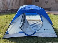 Front view of blue and grey 3 person dome tent with open zippered door showing interior and mesh window.