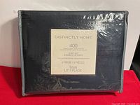 Front view of sealed black bedding set package showing brand and product details