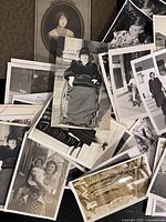 Close view of several black and white vintage photographs showing portraits and various candid scenes including a woman in a wheelchair and children.