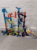 Large assembled marble run set showing colorful tubes and ramps, alongside Crazy Forts box.