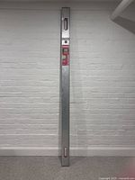 Full view of the 200cm aluminium screeding level with two visible bubble vial windows at top and bottom ends.