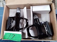 Boxed pair of black Biomec bicycle pedals showing the pedals from the top, revealing their metallic parts and spring mechanism.