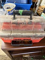 Closed Black & Decker drill bits carrying case with handle and transparent lid showing drill bits inside.