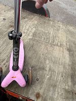 Front view of pink Micro scooter showing the brand logo on the front triangular base and two front wheels.