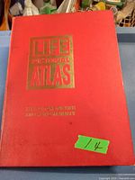 Front cover of a large red Life Pictorial Atlas hardcover book with gold embossed text.