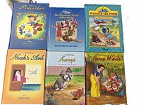 Photo showing six Disney-themed books arranged in two rows with visible titles and cover illustrations.