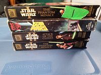 Side views of four Star Wars VHS tapes showing titles The Phantom Menace and Attack of the Clones.
