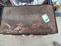 Top view of the old metal toolbox showing extensive rust and peeling paint.