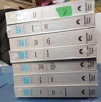 Six factory sealed Star Trek The Next Generation VHS tapes stacked top-down with episode titles visible on the spines.