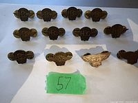 12 Harley Davidson collectible pins from different years shown on a white background with green tape marked 57