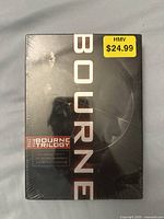 Front view of sealed Bourne Trilogy DVD box set with HMV $24.99 price sticker