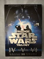 Front cover of Star Wars Original Trilogy DVD box set showing characters and title under 'Widescreen Panoramique'.
