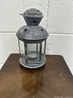 Front angle image of the galvanized metal hexagonal hanging lantern with glass sides and star-shaped cutouts on top.