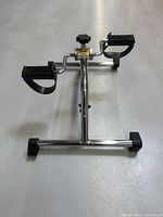 Front angled view of the Patterson Medical pedal exerciser showing pedals, resistance knob, and frame.