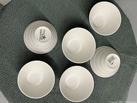 Top and bottom view of six white ridged ceramic cups with Royal Classic branding on base.
