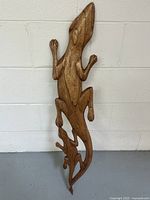 Front view of wooden carved wall panel showing three geckos in a vertical arrangement.