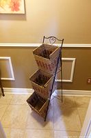 Full view of metal stand holding three wicker baskets