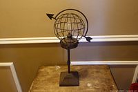 Full view of metal armillary globe lamp on table