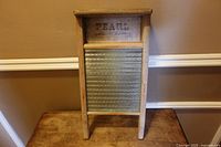 Front view of wood framed washboard with glass ridged panel and stamped brand