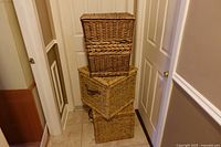 Three stacked rectangular wicker baskets with lids