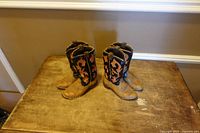 Two matching cowboy boot-shaped bookends on table