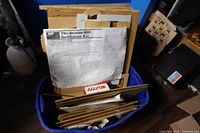 Kit contents in bin showing pre-cut wood panels and schematic drawings