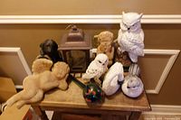 Group of garden statues, lantern and gazing ball on table