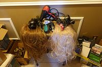 Front view of wigs and styling tools on table