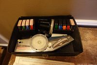 Overhead view of open case showing chrome label maker, tape cartridges, and paperwork