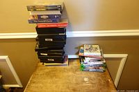 Full view of two stacks containing VHS tapes, DVDs, and video game cases