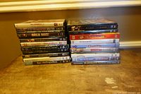 Two stacks of 19 DVD movies on tabletop showing spines and titles