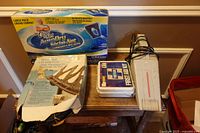 Grouping on table: auto drying cloth pack, dock ramp box, first aid kit, grey electronic unit