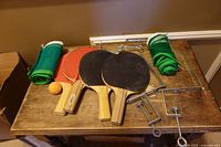 Overall lot showing paddles, nets, clamps and ball on table