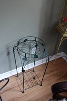 Full view of steel plant stand with decorative leaves and circular pot holder