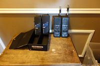 Four handheld CB radios—two with antennas, two in holder—on tabletop