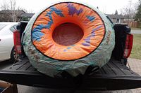 Full view of the inflatable water biscuit towable tube on a truck bed