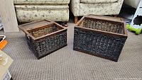 Two wooden wicker boxes, one smaller and one larger, placed on carpeted floor near furniture